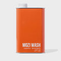 Orange can of Mozi Wash laundry detergent on a white background
